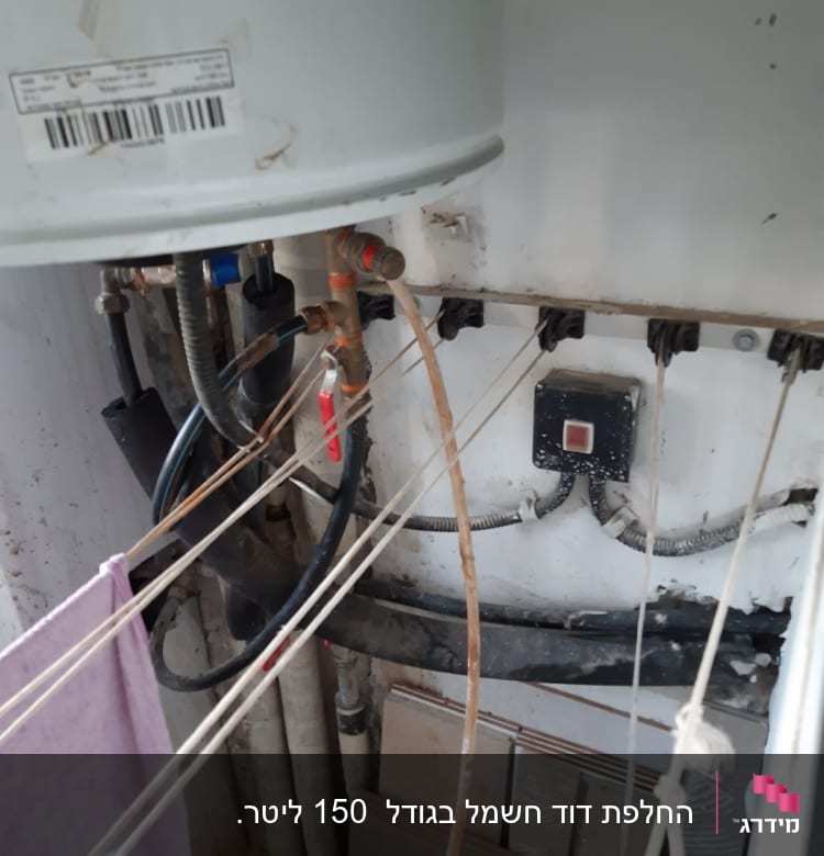 דוד שמש עם צינורות ומתג חשמלי על קיר